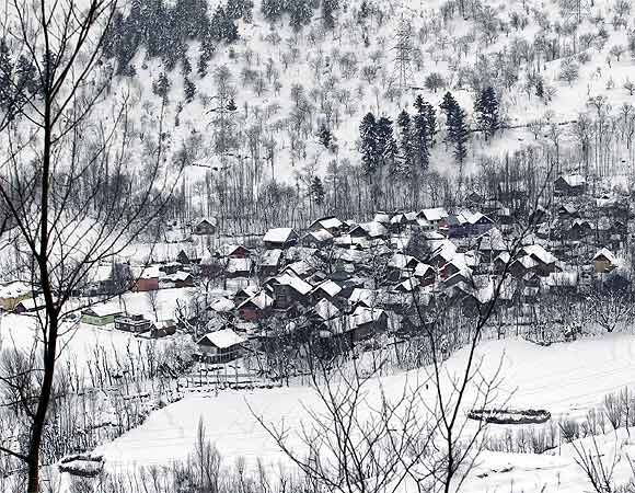 A view of snow-covered houses seen from Srinagar-Jammu highway