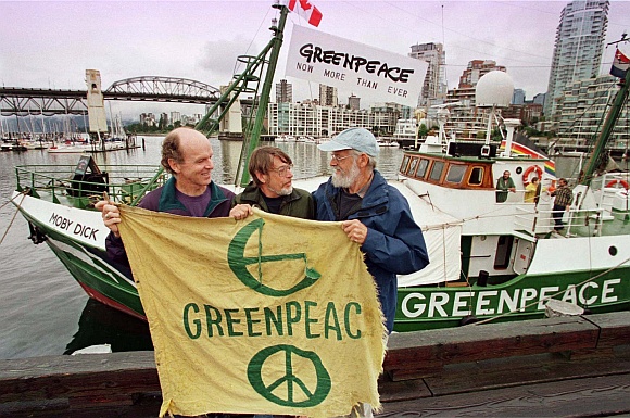Three founding members of Greenpeace Bill Darnell (L), Lyle Thurston (C) and Jim Bohlen (R) hold the original banner as they stand in front of one of the group's current vessels, the 'Moby Dick' during celebrations of Greenpeace's 25th anniversary in Vancouver