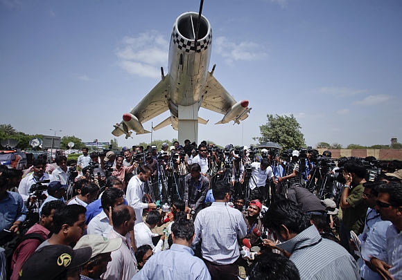 Media gather at the gates of the Mehran naval aviation base after troops ended operations against militants in Karachi