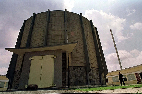 A worker is dwarfed by a rusting United States-built Buck Rogers-style reactor at Vietnam's Atomic Research Centre, containing the deadly plutonium left by the U S in March 1975 following the end of the war