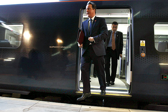 Britain's Prime Minister David Cameron exits a train at Stratford station to attend a cabinet meeting at the 2012 Olympic Games site in London