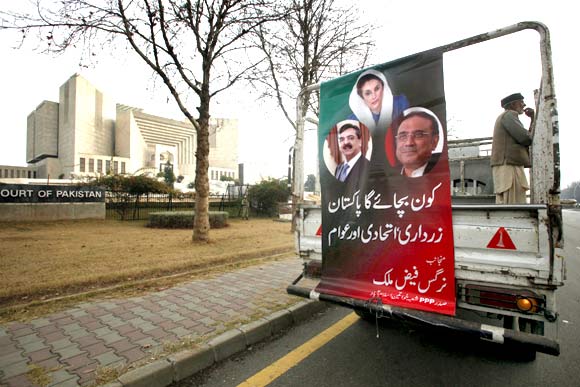 A banner bearing images of Pakistan's Prime Minister Yusuf Raza Gilani, assassinated former prime minister Benazir Bhutto and President Asif Ali Zardari outside the supreme court building in Islamabad