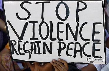 A girl holds a placard during a protest against attacks on churches