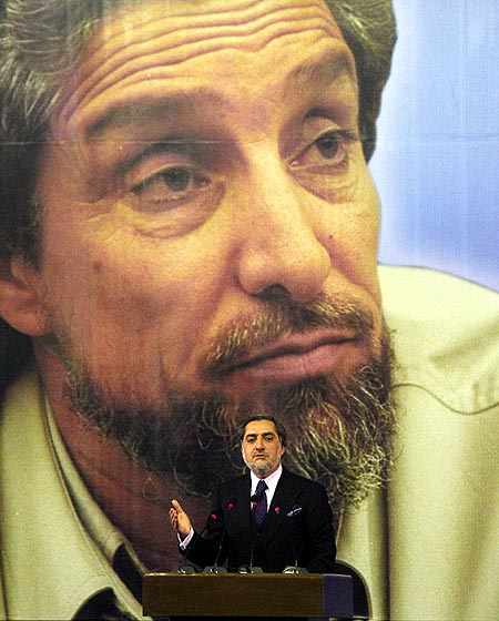 Former Afghan foreign minister Abdullah Abdullah in front of a poster of slain Northern Alliance chief Ahmad Shah Masoud.