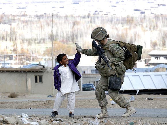 A US Army soldier with a local boy during a patrol in Pul-e Alam, a town in Logar province, Afghanistan.