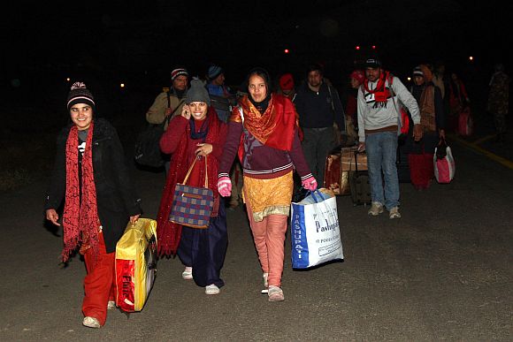All smiles: Rescued tourists exit the runway at the Jammu air base