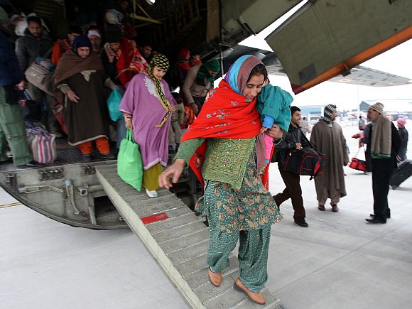 Rescued civilians disembark on arrival at the Jammu air base