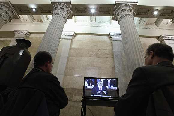 Journalists watch a television broadcast of Obama's speech