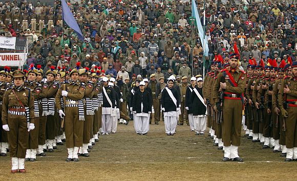 People watch police contingents perform a salute