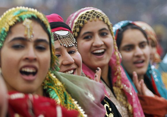 Kashmiri schoolgirls wearing traditional dresses perform to a patriotic song