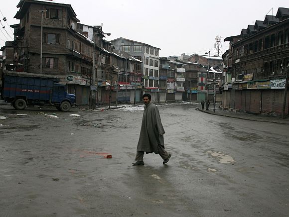 A Kashmiri crosses a deserted street