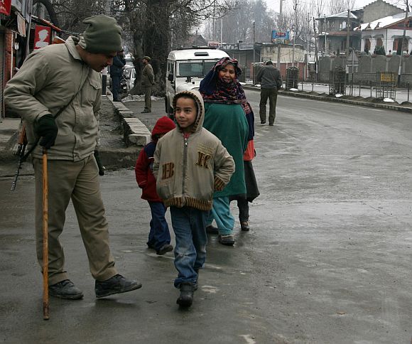 A policeman shares a light moment with a Kashmiri boy
