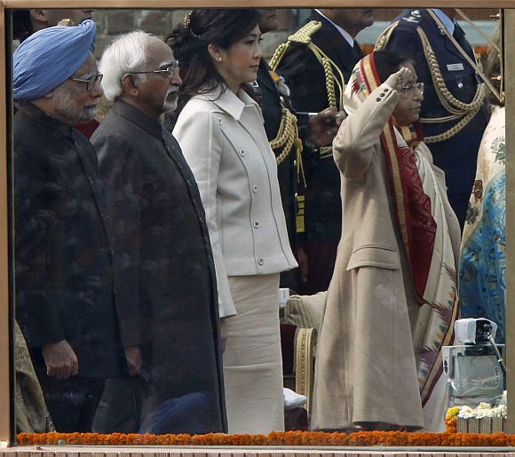 (From L - R) Prime Minister Manmohan Singh, Vice President Mohammad Hamid Ansari, Thailand's Prime Minister Yingluck Shinawatra and President Pratibha Patil stand behind a bullet-proof glass during India's national anthem at the Republic Day parade
