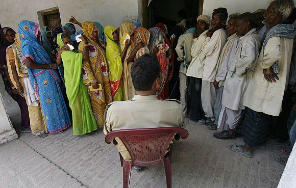 Voters wait to cast their votes in Rohania, UP