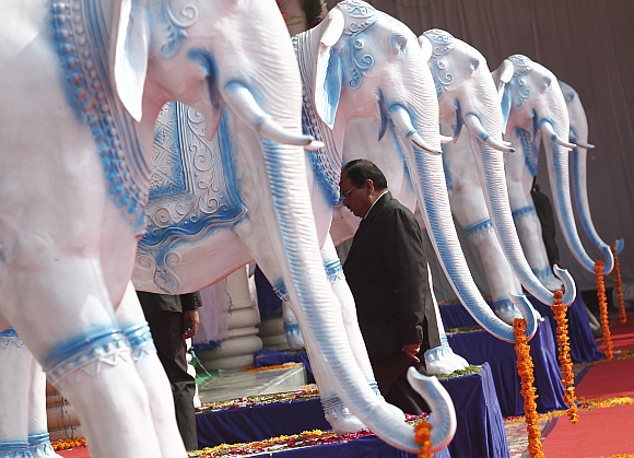 A Bahujan Samaj Party worker walks past statues of elephants, the BSP's electoral symbol, at the party headquarters in Lucknow