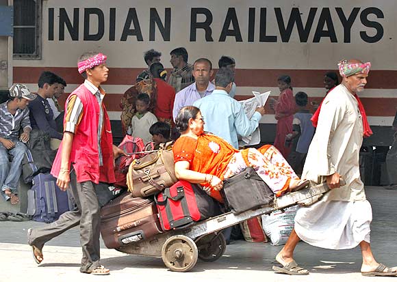 Porters transport a passenger and her luggage in Kolkata