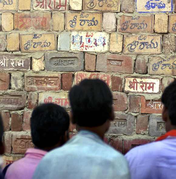 Hindu activists look at a temple wall where devotees have written the name of  Lord Ram in Ayodhya