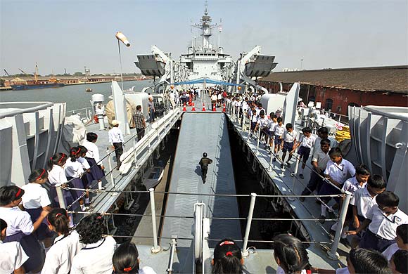 School children walk on Indian Naval Ship Airavat