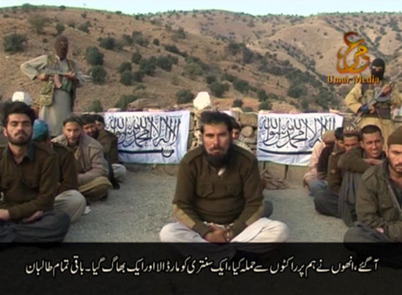 Handcuffed Pakistani soldiers with Taliban fighters in this still image taken from a video