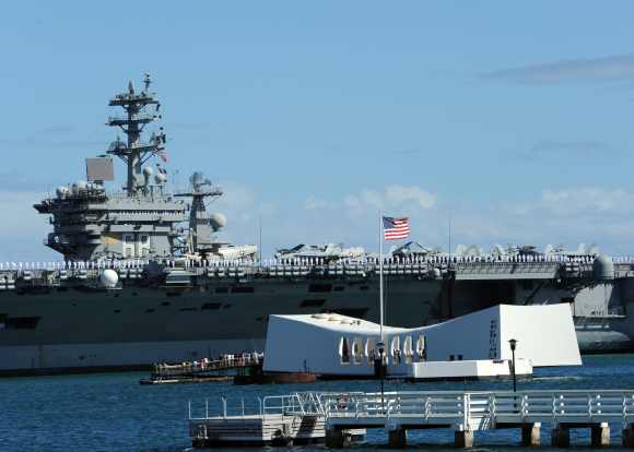 The aircraft carrier USS Nimitz passes the USS Arizona Memorial in Pearl Harbor. Nimitz is participating in the biennial Rim of the Pacific exercise 2012, the world's largest international maritime exercise