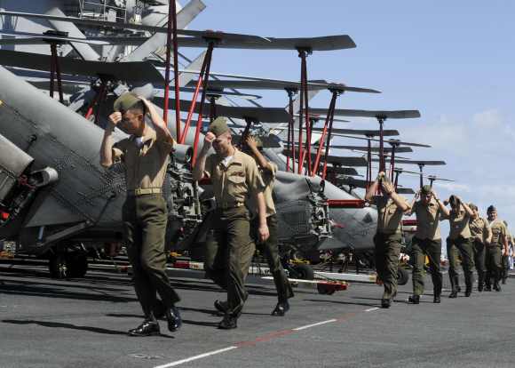 Marines from Marine Fighter Attack Squadron 323 prepare to man the rails as the aircraft carrier USS Nimitz enters Pearl Harbour