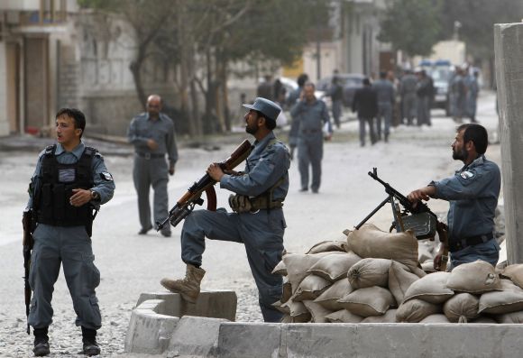 Afghan policemen take positions after a Taliban-triggered suicide blast in Kabul