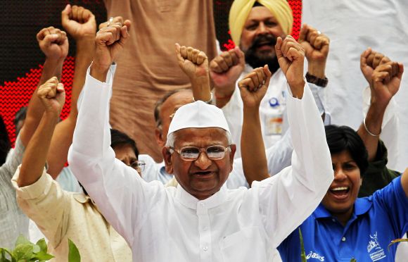 Anna Hazare raises his hands as he shouts slogans with supporters during an anti-corruption demonstration in New Delhi