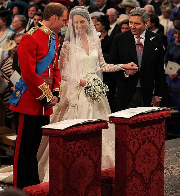 Britain's Prince William stands at the altar with his bride, Kate Middleton, and her father Michael, during their wedding ceremony at Westminster Abbey in central London April 29, 2011