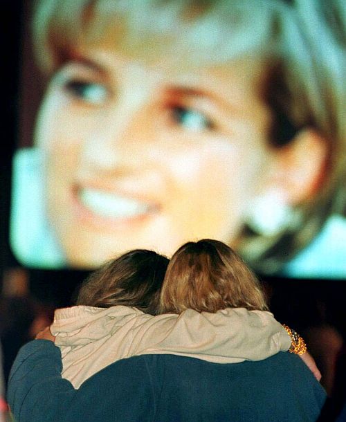 Two Atlanta women embrace September 6 as they watch the funeral coverage of Diana, Princess of Wales on a large screen television in an early morning gathering at a park in Atlanta