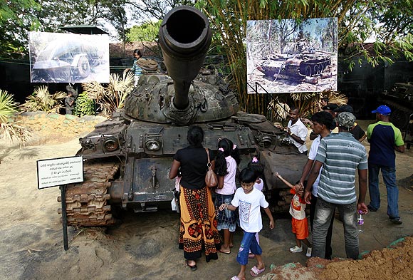 Members of the public look at a Liberation Tigers of Tamil Eelam tank captured during the war, in Colombo