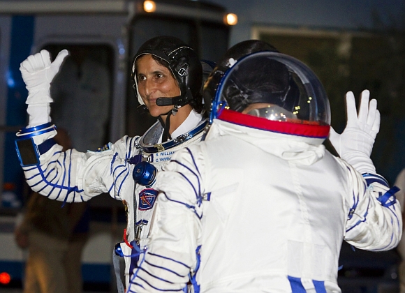 International Space Station crew member United States astronaut Sunita Williams waves after reporting to members of the State Committee before the launch of the Soyuz TMA-05M spacecraft at Baikonur cosmodrome