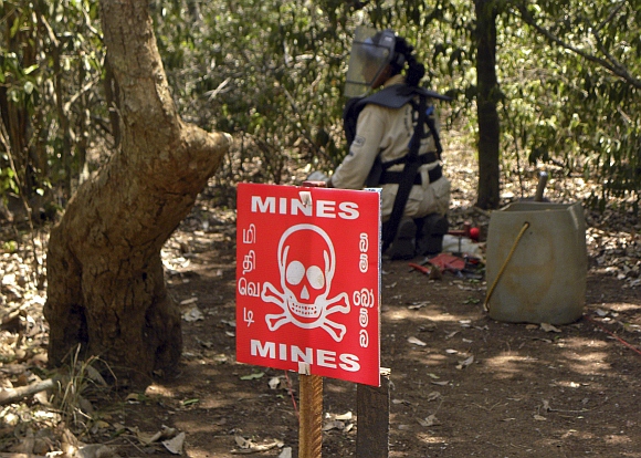 A de-miner searches for mines in a mine field in Kannaddi, located in Mannar district in Sri Lanka