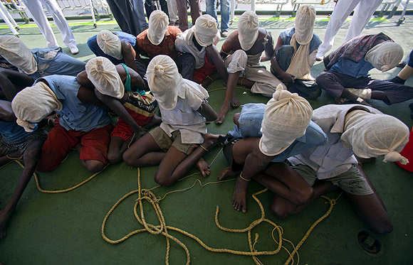 Suspected Somali pirates sit with their faces covered with cloth sacks on the deck of an Indian Coast Guard vessel in Mumbai