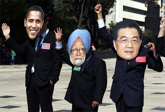 Activists wear masks of G-20 leaders (L-R) U.S. President Barack Obama, Prime Minister Manmohan Singh and Chinese President Hu Jintao