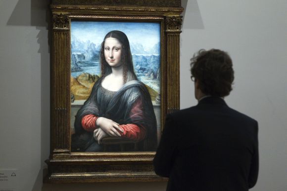 A visitor looks at a copy of Da Vinci's 'Mona Lisa' painting at a museum in Paris