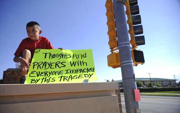 Brendon Hutchinson, 11, of Aurora, Colorado sits at the intersection north of the Century 16 theater shootings in Aurora