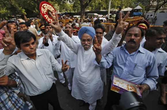 A Congress supporter dressed as PM Manmohan Singh celebrates with other supporters the election of their leader Mukherjee as India's 13th president in New Delhi