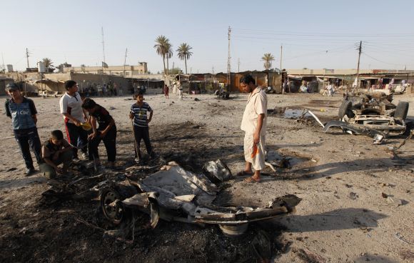 Residents gather at the site of a car bomb attack in Mahmudiya, 30 km south of Baghdad, on Monday.