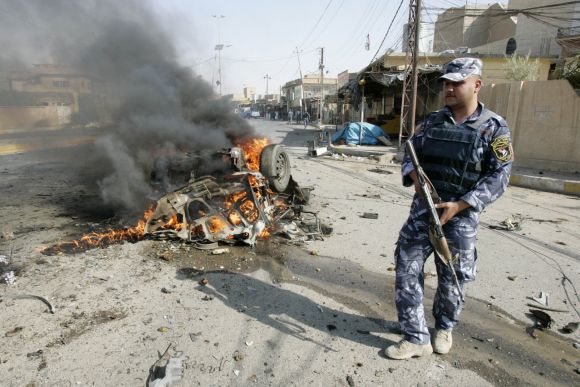 A policeman stands guard at the site of a bomb attack in Kirkuk, on Monday