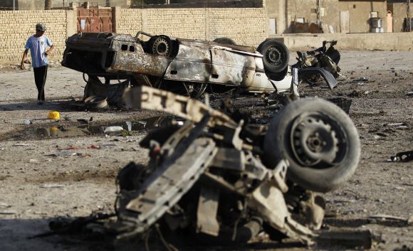 A boy stands near the site of a car bomb attack in Mahmudiya, on Monday