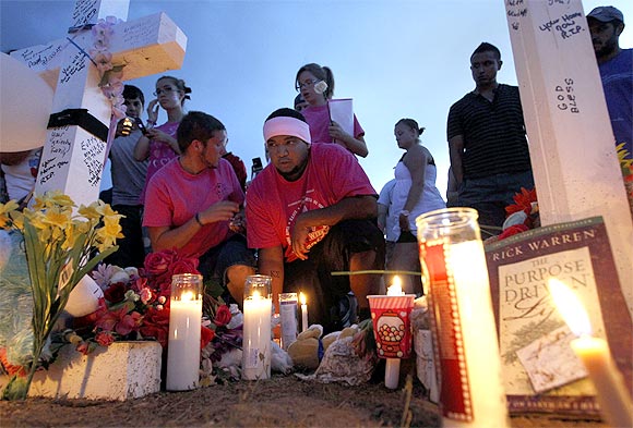 People grieve at a memorial for victims behind the theatre in Aurora