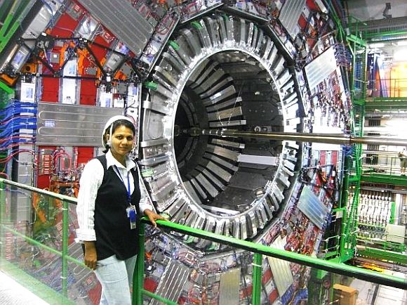 Archana Sharma stands next to the Large Hadron Collider at the CERN facility