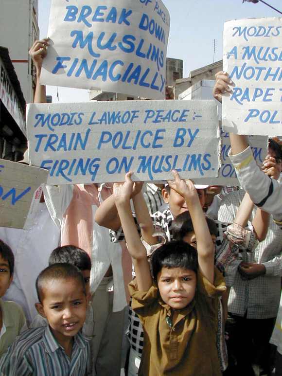 Young Muslims hold placards denouncing Gujarat state chief minister Narendra Modi during a peace march in Ahmedabad
