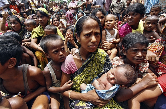 Villagers affected by ethnic riots are seen inside a relief camp with their children near Bijni
