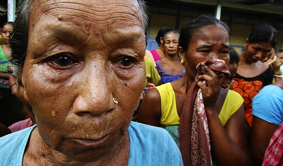 Village women affected by the ethnic riots, cry after their houses were burnt during violence, at a relief camp at Goshaigaon in Assam