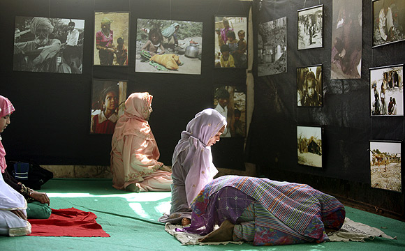 Muslims pray in a hall where a photo exhibition on Gujarat riots is being held