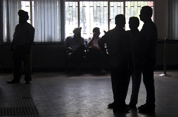 People stand inside the driving registration and license authority office during a power-cut in Chandigarh