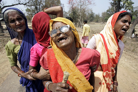 Relatives of tribal militias killed in a Maoist attack cry at the cremation in Mangapeta village, about 450 km from Raipur