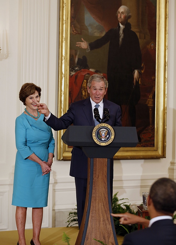 Former US President George W Bush stands next to former first lady Laura Bush while speaking during the unveiling of their official White House portraits in the East Room of the White House in Washington. US President Barack Obama is seen at the lower right corner