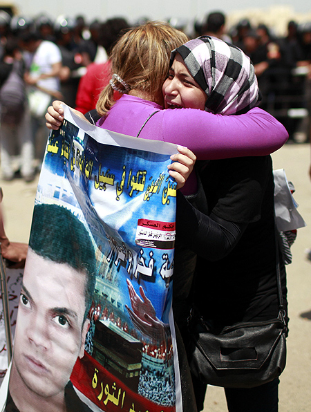 Relatives of people who died during Egypt's revolutions hug each other after the sentencing